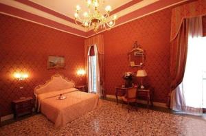 a red bedroom with a bed and a chandelier at Residenza Hotel San Maurizio in Venice