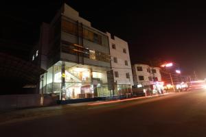 a building on the side of a street at night at Hotel Finch in Erāttupetta