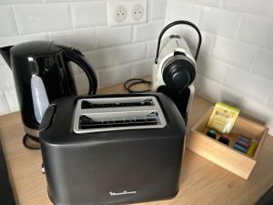a black toaster sitting on a counter next to a cup at House with a fantastic panoramic view in Le Pecq
