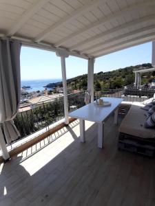 a white table on a balcony with a view of the ocean at DIMAKI'S house in Patitiri