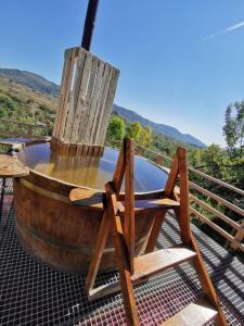 a wooden chair sitting on top of a deck at Cabana Tinca in Corbeni