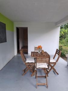 een houten tafel en stoelen op een patio bij Romantischer studio mit grosser Terrasse in Salavaux