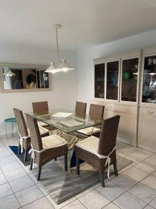 ein Esszimmer mit Glastisch und Stühlen in der Unterkunft Maison spacieuse avec piscine in Guidel + 18 Fotos