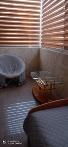 1 dormitorio con cama, mesa de cristal y reposapiés en Берізка, en Voznesensk