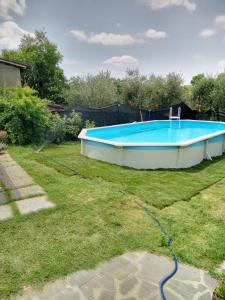 ein großer Pool in einem Garten mit einem Schlauch in der Unterkunft Sassaia11 in Arezzo