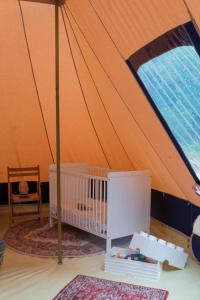 una camera con una tenda e una culla. di Luxe tent Kruimeltje 