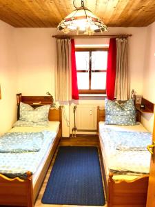 Duas camas num pequeno quarto com uma janela em SIMPLY-THE-BEST-Ferienwohnung-mit-Pool-Sauna-Schwimmbad-bis-6-Personen em Hauzenberg