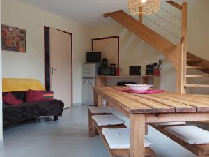 ein Wohnzimmer mit einem Holztisch und einer Treppe in der Unterkunft La Valette in Ménil-Hubert-sur-Orne