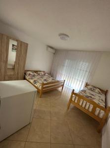 a room with two beds and a refrigerator at Apartments Edona in Ulcinj