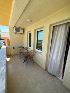 a balcony with a table and chairs and a window at Apartments Edona in Ulcinj