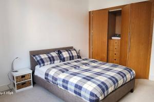 - une chambre avec un lit et une armoire en bois dans l'établissement Spacious 2 bedroom apartment, à Édimbourg