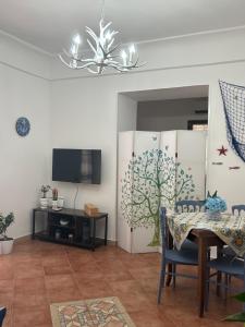 comedor con mesa y TV en Sissi House Salerno, en Salerno