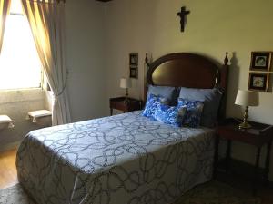 1 dormitorio con 1 cama y 1 cruz en la pared en Casa do Rocio, 