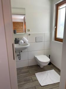 ein weißes Bad mit einem WC und einem Waschbecken in der Unterkunft Henry's in Sankt Anton am Arlberg