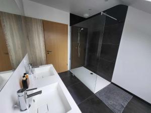 uma casa de banho com um lavatório branco e um chuveiro em Chambre London proche du circuit em Spa
