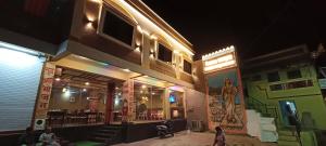 a building with a restaurant at night at Hotel Maheshwar Darshan in Maheshwar
