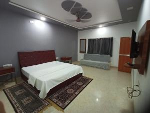 a bedroom with a bed and a tv in it at Hotel Maheshwar Darshan in Maheshwar