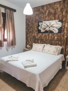 um quarto com uma cama grande e lençóis brancos em Aroma Studios and Apartments em Vourvourou