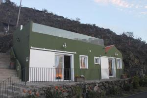 uma casa verde e branca no lado de uma colina em Casa Los Bernales em Las Indias
