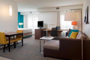 a hotel room with a couch and a bed at Residence Inn by Marriott Orlando at SeaWorld in Orlando