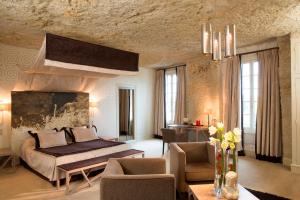 een slaapkamer met een bed en een woonkamer bij Hotel Les Hautes Roches in Rochecorbon