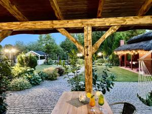 a wooden pergola with a wooden table in a garden at Gościniec Joanna in Rajgród