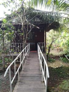 uma passagem de madeira que leva a uma cabina com uma ponte em Quoc Phuong Riverside Homestay em Ben Tre