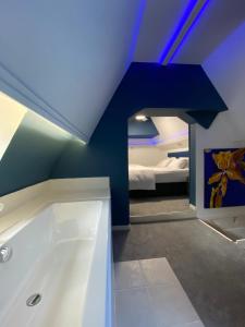a room with a bath tub and a bedroom at Charme rustique- piscine privée et jardin in Queyssac +18 photos