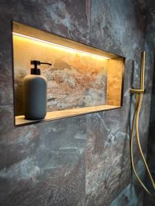 a bathroom with a soap dispenser on a wall at Tethera, Amma Barn in Shap