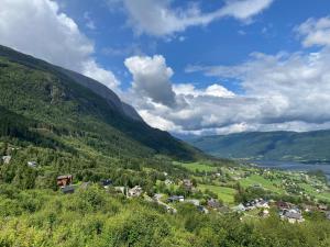 a village in a valley with a lake and mountains at Voss - Flott hytte i Bavallen in Skulestadmo