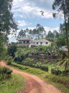 una casa en una colina al lado de un camino de tierra en The Fortuna Hotel and Cafe, en Kabale