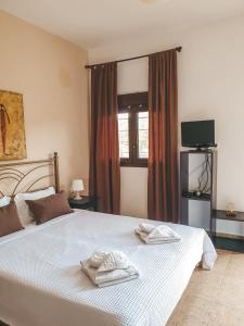 a bedroom with a bed with two towels on it at Aroma Studios and Apartments in Vourvourou