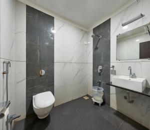 a bathroom with a toilet and a sink at Hotel Fortune Inn in Kolhapur