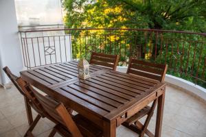 a wooden table and two chairs on a balcony at Odysseas Home Kalamata in Kalamata
