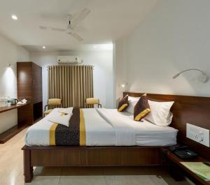ein Schlafzimmer mit einem großen Bett in einem Zimmer in der Unterkunft Hotel Fortune Inn in Kolhapur