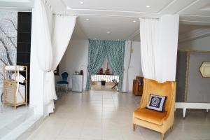 a living room with white curtains and a chair at Riad Ras Lafaa in Safi