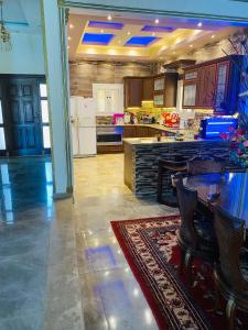 a large kitchen with a table and a counter at Lovely Villa 5- bedroom with Overflow Pool with Nice Garden at Green Oasis Resort in Alexandria