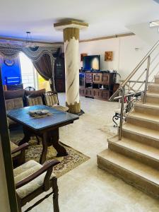 a living room with a table and some stairs at Lovely Villa 5- bedroom with Overflow Pool with Nice Garden at Green Oasis Resort in Alexandria