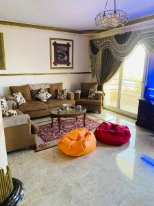 a living room with a couch and two ottomans at Lovely Villa 5- bedroom with Overflow Pool with Nice Garden at Green Oasis Resort in Alexandria