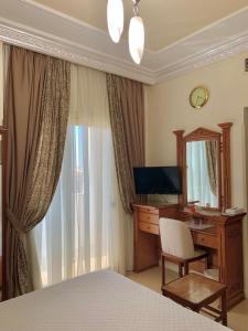 um quarto com uma secretária, um computador e um espelho. em Teba Hotel Ras Elbar em Ras El Bar
