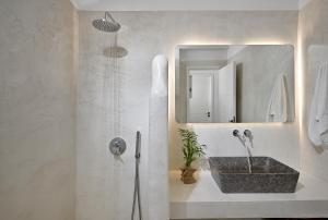 a bathroom with a sink and a mirror at VLIA MAR Myconian Residences in Kalafatis