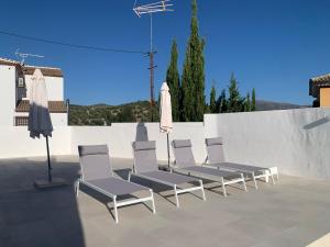 a group of chairs and umbrellas on a patio at Casa Genilla in Priego de Córdoba
