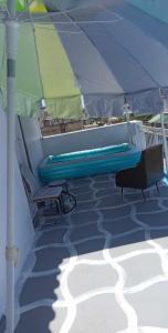 a bench and two chairs under an umbrella on a boat at Θέρετρο Γαλάζιου Ουρανού in Athens