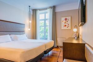 una camera d'albergo con letto e finestra di Hotel Compostela a Santiago de Compostela
