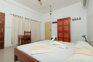 a bedroom with a bed with a swan on it at Ashirvad Homestay, Ashtamudi Lake, Kollam in Kollam