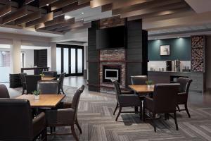 um restaurante com mesas e cadeiras e uma lareira em Delta Hotels by Marriott Guelph Conference Centre em Guelph