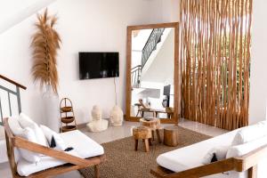 a living room with white furniture and a mirror at Villa Diola 1 in Canggu