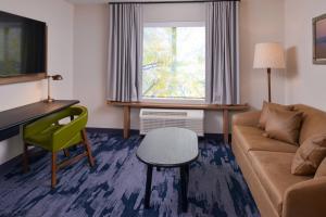 a living room with a couch and a desk and a chair at Fairfield Inn & Suites by Marriott Columbus Grove City in Grove City
