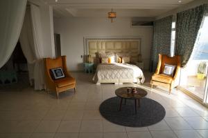a bedroom with a bed and two chairs and a table at Riad Ras Lafaa in Safi