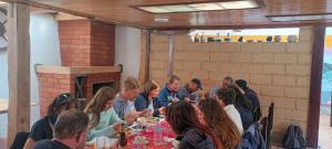 un grupo de personas sentadas en una mesa comiendo en Hostal el castillo ingapirca, en Ingapirca
